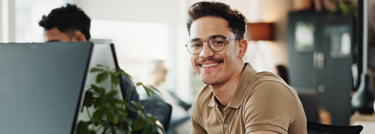 Een glimlachende man werkt op een computer