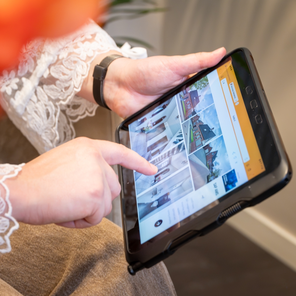 Een vrouw kijkt op haar laptop naar de website Funda voor een woning